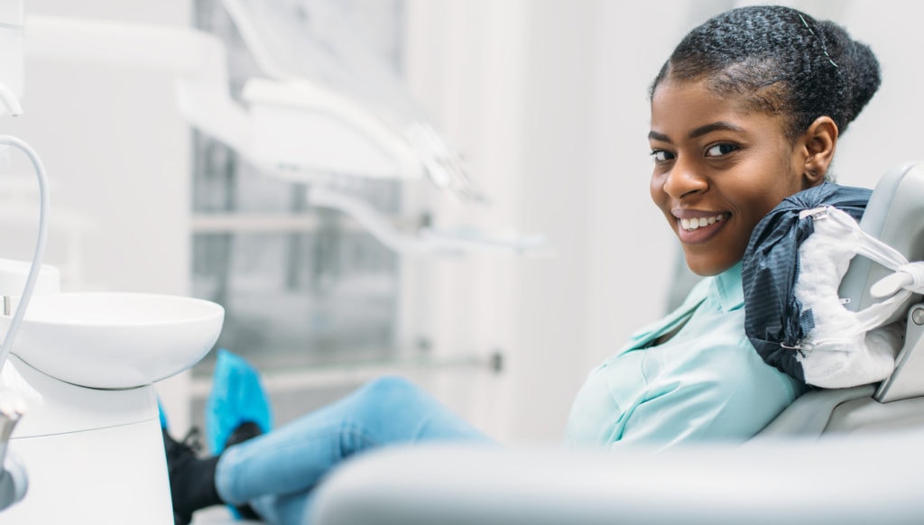 Woman waits in a dentist chair for a teeth cleaning